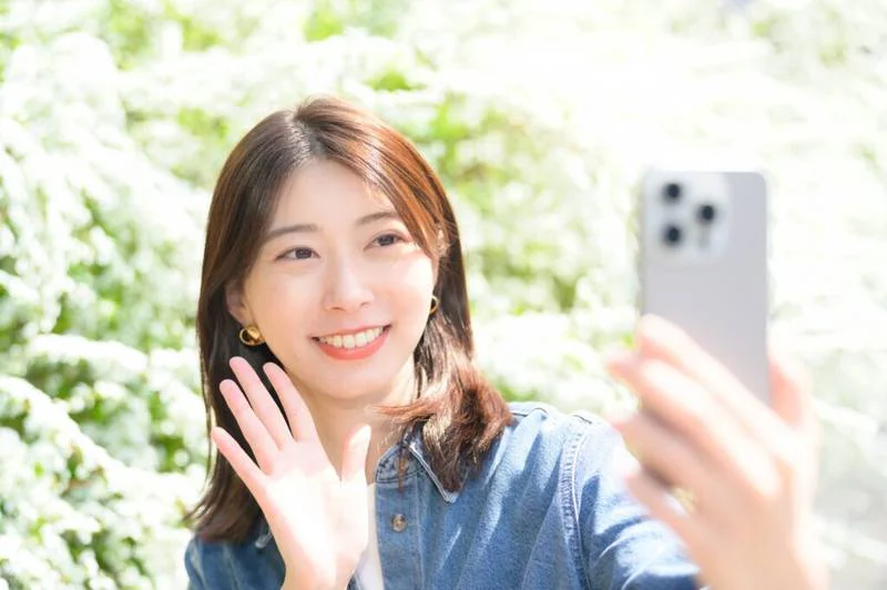 スマートフォンのカメラに手を振るライバー